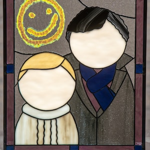 May include: A stained glass window with two figures, one with a blue scarf and the other with a white collar. A yellow smiley face is in the top left corner.