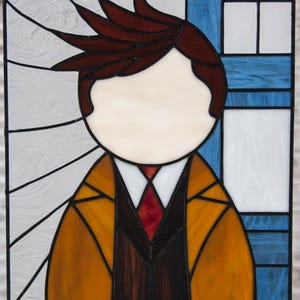 May include: Stained glass window featuring a person with brown hair, wearing a brown jacket, white shirt, and red tie. The background is a blue and white stained glass design.