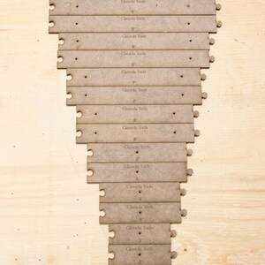 May include: A set of 18 wooden rulers, each with a different length, ranging from 2 inches to 10 inches. The rulers are labeled with the length and the brand name "Glassola Tools".