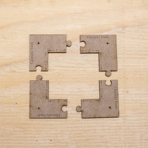 May include: Four brown wooden puzzle pieces with the text "Glassola Tools" printed on each piece. The pieces are arranged in a square shape, with the text facing outwards.