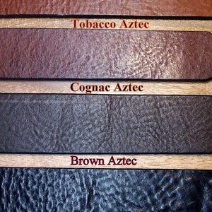 Puede incluir: Primer plano de muestras de cuero en varios tonos de marr&oacute;n y negro. Las muestras est&aacute;n etiquetadas como "Tobacco Aztec", "Cognac Aztec", "Brown Aztec" y "Black Aztec". El cuero tiene un aspecto texturizado.