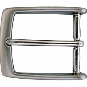 May include: A silver metal belt buckle with a smooth, rounded finish.