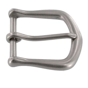May include: A silver-toned metal buckle with a rounded, curved design. The buckle has a single prong and is designed for a belt.