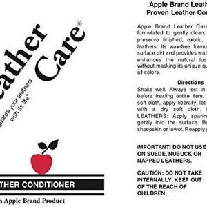 May include: A bottle of Apple Brand Leather Care Proven Leather Conditioner. The bottle has a red apple logo and the text "Leather Care" in a black and white logo. The bottle is labeled with instructions for use and a warning to keep out of reach of children.