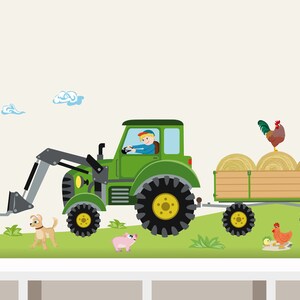Op de afbeelding: Een groene tractor met een aanhanger vol hooibalen. Een boer bestuurt de tractor. Er zijn ook een kat, een hond, een varken en een haan op de afbeelding.