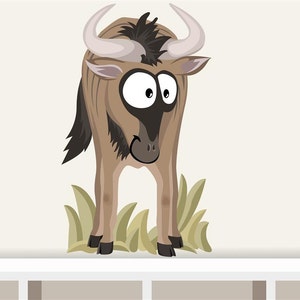 May include: A cartoon wildebeest illustration with large eyes and curved horns. The wildebeest is coloured in shades of brown and tan, with a black mane and tail. It stands in front of a patch of green grass against a neutral background.