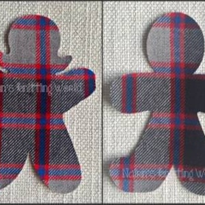 May include: Two fabric gingerbread person cutouts featuring a red, blue, and grey plaid pattern. The left cutout has a rounded head with hair-like protrusions, while the right is a standard shape. Both feature the text Nairn's Knitting World.