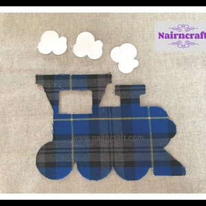 May include: A fabric appliqué in the shape of a steam train engine featuring a blue, black, and yellow plaid pattern, accompanied by three white cloud-shaped fabric pieces and a rectangular label with the text Nairncraft in purple.