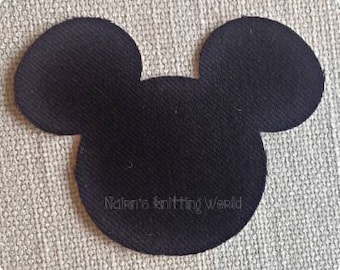 May include: A black fabric patch shaped like a mouse head silhouette with two large circular ears. The text Nalen's knitting World is embroidered in a thin, light-colored thread across the lower center of the black fabric surface.
