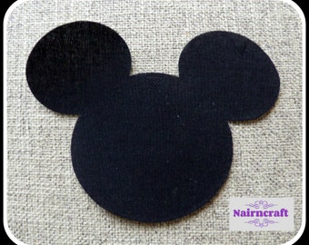 May include: A black felt cutout in the shape of a mouse head with two circular ears and a round face. In the bottom right corner, there is a white rectangular label with the purple text Nairncraft and decorative flourishes above and below.