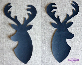 Op de afbeelding: Twee zwarte silhouetten van een hertenkop met gedetailleerd gewei en puntige oren. De uitsparingen zijn effen zwart met een gladde, matte afwerking en tonen het profiel van een hert dat naar rechts kijkt. Het ontwerp is strak en symmetrisch.