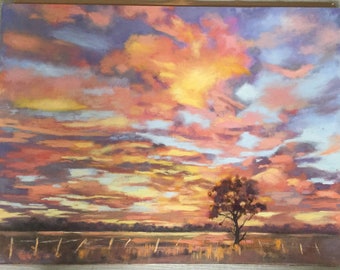 May include: A painting depicting a sunset over a field, featuring a solitary tree in the foreground. The sky is a blend of pink, orange, and yellow, with clouds in various shades of blue. The field is green, with a fence in the foreground.