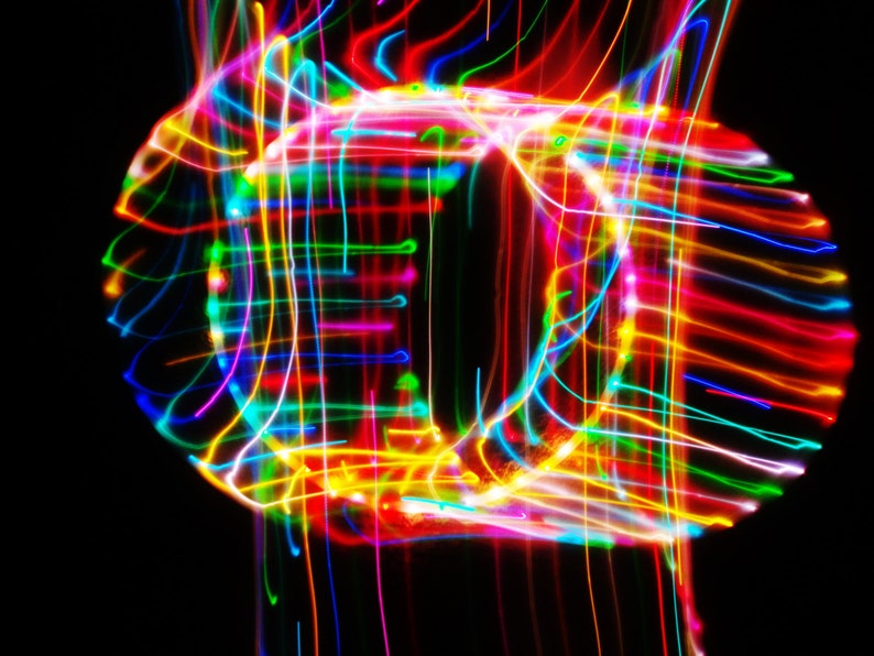 May include: Abstract image of colorful light trails creating a swirling, circular pattern against a black background.