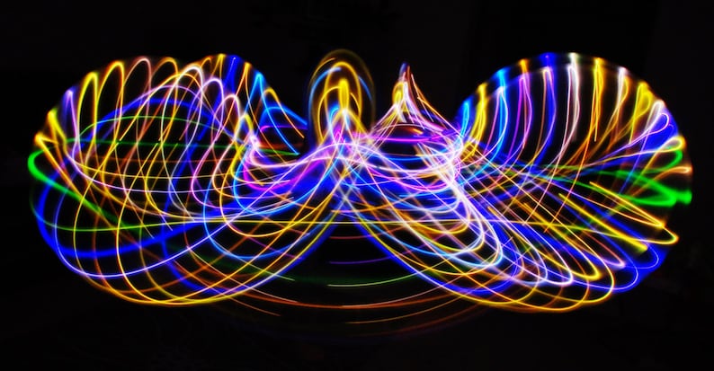 May include: Abstract light painting with swirling lines of blue, yellow, green, and purple light on a black background.