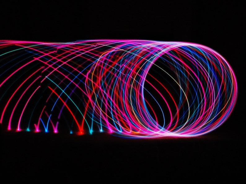 May include: Abstract image of colorful light trails in pink, blue, and red, creating a swirling, circular pattern against a black background.