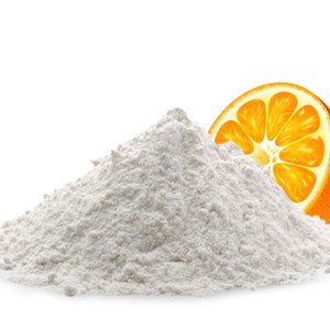 May include: A white powder pile with a half of an orange on top. The orange is bright orange with a yellow center.