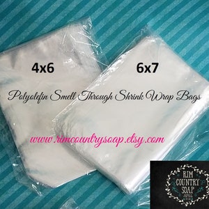 May include: Two stacks of clear plastic shrink wrap bags. The bags are labeled 4x6 and 6x7. The text "Polyolefin Smell Through Shrink Wrap Bags" is printed on the bags. The website address "www.rimcountrysoap.etsy.com" is printed on the bags.