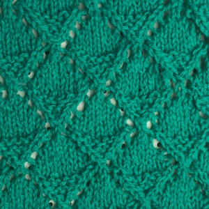 Könnte beinhalten: Nahaufnahme eines tealfarbenen Strickstoffes mit einem rautenförmigen Muster. Der Stoff hat ein zartes, durchbrochenes Design.