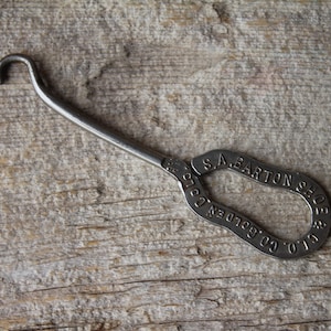 May include: A silver shoe horn with the inscription "S.A. Barton & Co. Golden  Co."