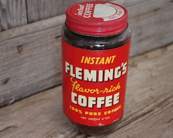 May include: A red and white jar of instant coffee labelled "Fleming's Flavor-rich Coffee" with the text "100% Pure Coffee" and "Net Weight 6 oz."