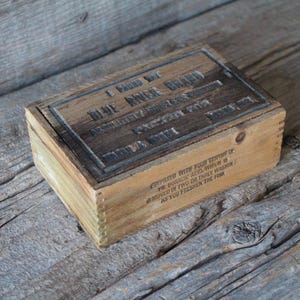 May include: A wooden box with the text "I have but one BLUE RIVER BRAND ABSOLUTELY PURE & BEST FOR EVERY USE" printed on the top. The box is made of wood and has a rustic look.