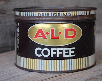 May include: Vintage metal coffee can with gold and white stripes. The can has a brown label with the text "A.L.D. COFFEE" in red and white letters.