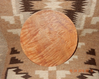 May include: A round wooden platter with a natural wood finish and a unique grain pattern. The platter is approximately 12 inches in diameter.