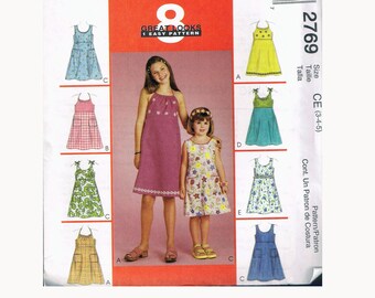 May include: A sewing pattern for a girls' dress with eight different variations. The pattern is for sizes 3-4-5 and is called "Great Looks 1 Easy Pattern".