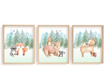 May include: Set of three framed watercolor prints featuring woodland animals. Each print showcases a different animal pair or group: a raccoon and fox, a bear with a rabbit and skunk, and a deer with a bird and squirrel. The background depicts a forest.