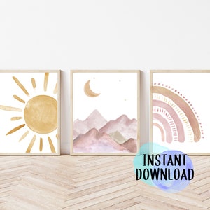 May include: Three framed watercolor art prints featuring a sun, mountains with a crescent moon, and a rainbow. The artwork uses a soft, muted color palette of gold, pink, and brown. The phrase "INSTANT DOWNLOAD" is visible in the bottom right corner.