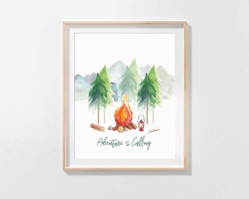 May include: Watercolor print of a campfire scene with the text "Adventure is Calling." The artwork features a campfire with flames, trees, mountains, and a lantern. The print is framed in a light wood frame.