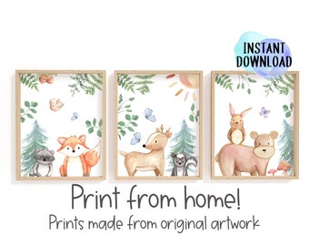 Peut inclure: Ensemble de trois impressions encadrées à l'aquarelle représentant des animaux de la forêt. Les impressions incluent un raton laveur et un renard, un cerf et une moufette, et un ours et un lapin. La verdure et les papillons entourent les animaux. Le texte dit "Print from home!"