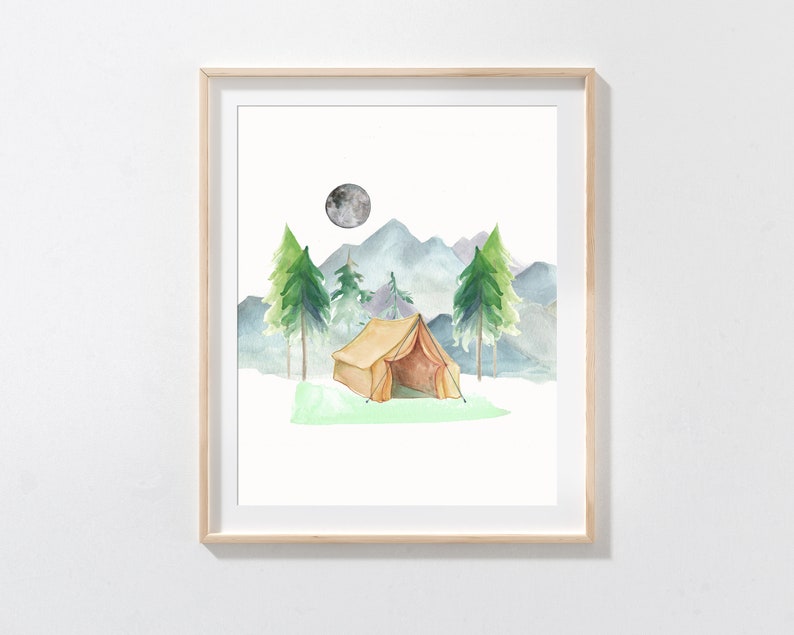 May include: Watercolor painting of a camping scene. A tan tent sits on green grass, with green trees and blue mountains in the background. A gray moon is in the sky. The artwork is framed in a light wood frame.