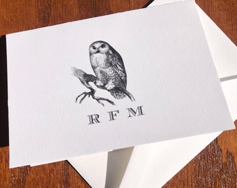 May include: A white card with a black and white illustration of an owl perched on a branch. The letters RFM are printed below the owl.