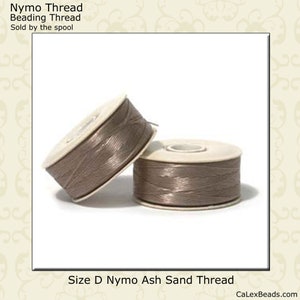 May include: Two spools of size D Nymo beading thread in the color Ash Sand. The thread is a light brown color.