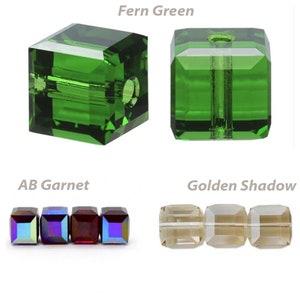 May include: Three different colors of square glass beads. The first bead is a bright green color, the second bead is a dark green color with a rainbow iridescent finish, and the third bead is a light brown color.