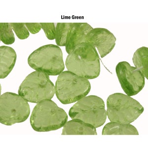 Op de afbeelding: Limoengroene hartvormige kralen. De doorschijnende kralen zijn verspreid tegen een witte achtergrond. De tekst "Lime Green" wordt in zwarte letters bovenaan de afbeelding weergegeven. Deze kralen zijn geschikt voor het maken van sieraden en knutselen.