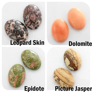 May include: Four pairs of oval-shaped cabochon gemstones. The top left pair is a leopard skin jasper, the top right pair is dolomite, the bottom left pair is epidote, and the bottom right pair is picture jasper.