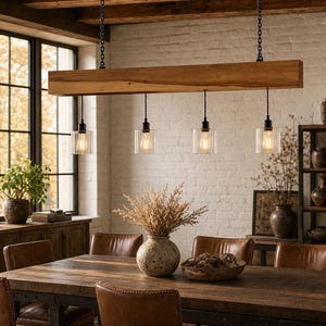 May include: A linear pendant light fixture featuring a long, rectangular natural wood beam suspended by two black metal chains. Four clear, vertically ribbed glass cylindrical shades hang from the beam, each containing a glowing Edison-style bulb.