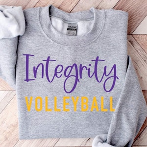 May include: Gray sweatshirt with the words "Integrity Volleyball" printed in purple and yellow lettering.