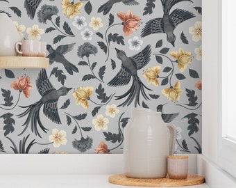 May include: Gray wallpaper featuring a repeating pattern of stylized birds and floral elements. The birds are dark gray with long tail feathers, and the flowers are in shades of yellow, peach, and white. The wallpaper is a decorative element for interior design.