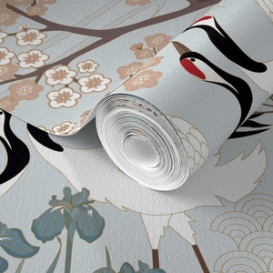 May include: A roll of blue and white wallpaper with a Japanese-inspired design featuring cranes, cherry blossoms, and irises. The wallpaper has a subtle shimmer and a textured finish.
