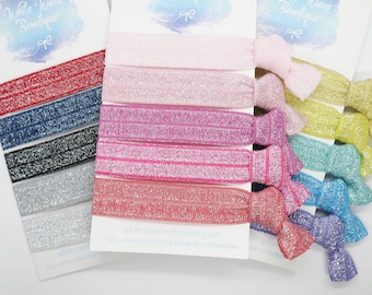 May include: A set of 10 sparkly hair ties in various colors, including pink, red, blue, and green. The hair ties are arranged on a white background with the text "White Wave Bowlique" and the website address "whitewavebowtique.etsy.com".