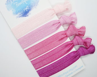 May include: A set of six pink hair ties in varying shades, from light pink to deep magenta, arranged on a white card. The card features the text "White Wave Bowtique" in cursive script and the Etsy shop URL.