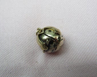 May include: A small, gold-colored globe charm with intricate detailing. The charm features visible lines representing continents and is suspended from a small loop. The surface has a slightly aged appearance, suggesting it is vintage or antique.