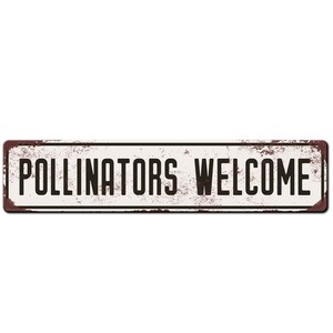 May include: A white metal sign with brown rust spots and black text that reads "Pollinators Welcome".