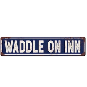 May include: A blue and white metal sign with the text "Waddle On Inn" in white lettering. The sign has a rustic, weathered look.