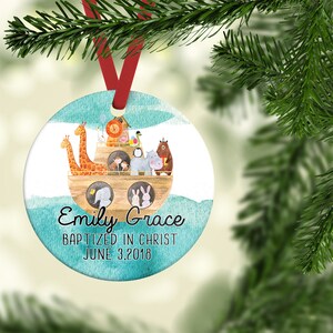 May include: A round, blue and white Christmas ornament with a watercolor illustration of a wooden ark filled with animals. The text "Emily Grace Baptized in Christ June 3, 2018" is written below the ark.