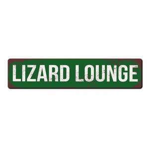 May include: A green and brown rectangular metal sign with the text "LIZARD LOUNGE" in white.