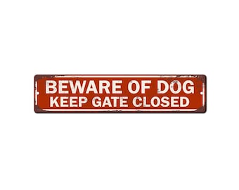 May include: A rectangular, rusty-red metal sign with the words "BEWARE OF DOG" above "KEEP GATE CLOSED" in white, distressed lettering. The sign has a weathered appearance, suggesting outdoor use.